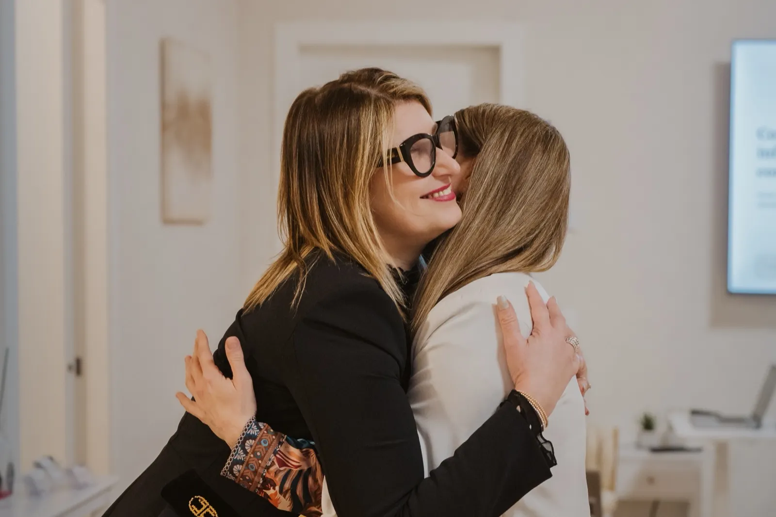 Cristiana Zanuccoli abbraccia sorridendo una persona al termine di un incontro in studio